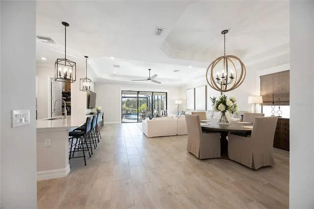 a view of a livingroom with a dinning area hardwood floor and a ceiling fan