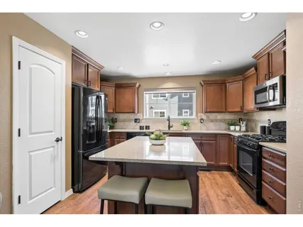 a kitchen with stainless steel appliances granite countertop a stove refrigerator sink and cabinets