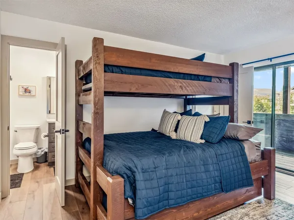 a bedroom with bed and wooden floor