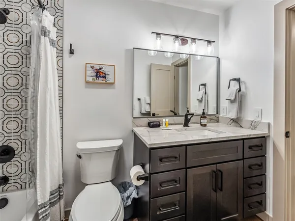 a bathroom with a toilet sink and mirror