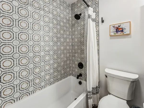 a bathroom with a toilet and a shower curtain