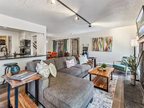 a living room with furniture kitchen view and a potted plant