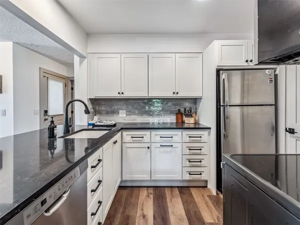 a kitchen with cabinets appliances and a sink