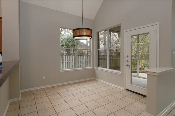 an empty room with windows fireplace and fans