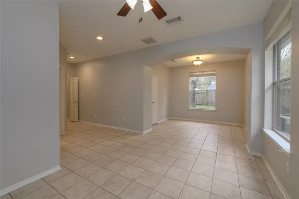 a view of an empty room and chandelier fan