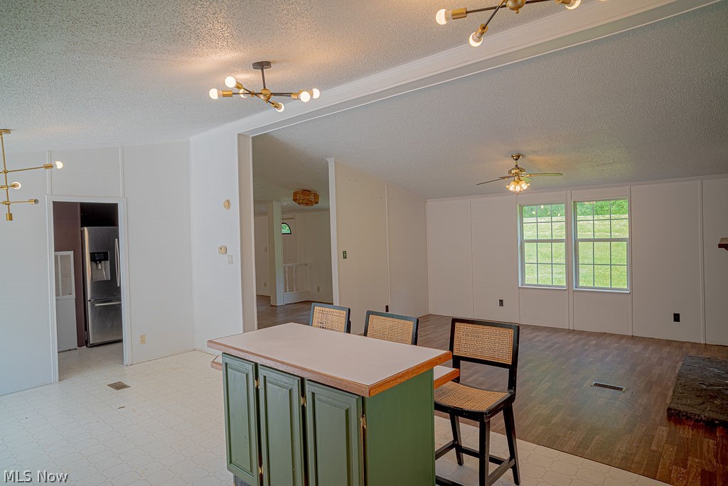 967 Buck Run Road Mineral Wells, WV 26150 - Photo 24 of 50 Open-concept living area featuring a kitchen island with built-in cabinetry, dual picture windows, and wood-finish flooring