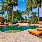 a view of a swimming pool with lounge chairs in a patio