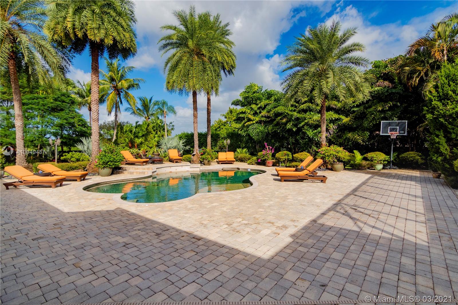 2273 Southwest 132nd Way Davie, FL 33325 - Photo 22 of 48 a view of a swimming pool with a lawn chairs under palm trees