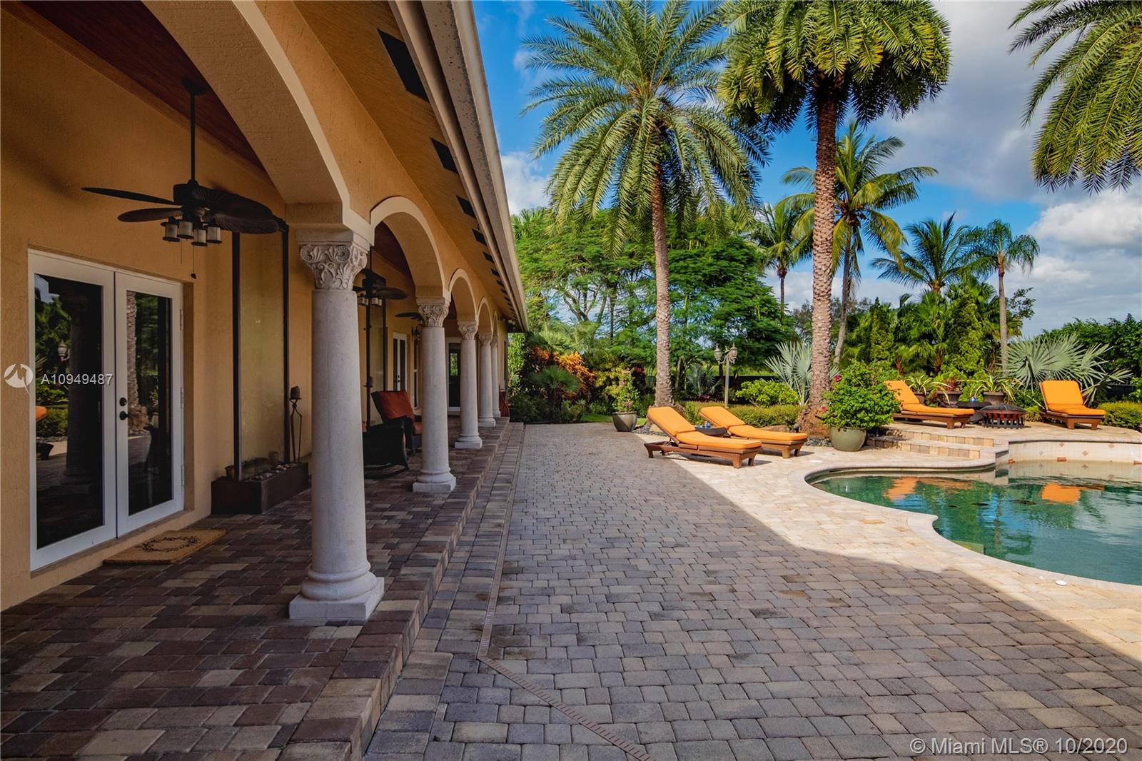 2273 Southwest 132nd Way Davie, FL 33325 - Photo 24 of 48 a view of a swimming pool with a lawn chairs and palm trees