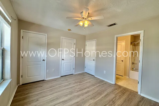 wooden floor in an empty room with a fan