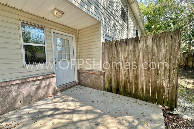 a view of a porch with a wooden door and a chair