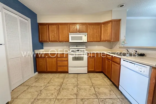 a kitchen with a stove sink and cabinets