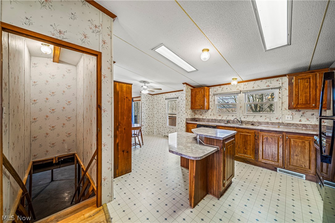 3471 Fox Road Kingsville, OH 44048 - Photo 14 of 50 Kitchen with light tile floors, a textured ceiling, ceiling fan, and sink