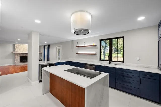 a large kitchen with stainless steel appliances kitchen island granite countertop a refrigerator and a stove