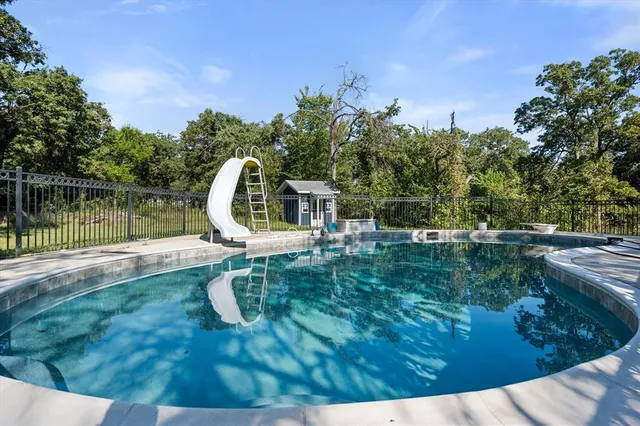 a swimming pool with trees in the background