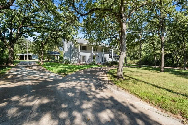 a view of a house with backyard and trees