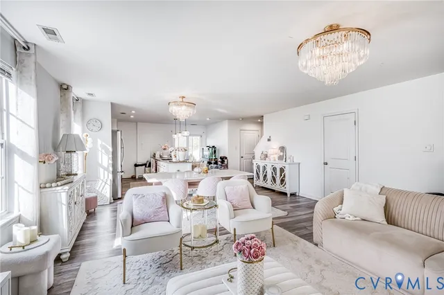 a living room with furniture and a chandelier
