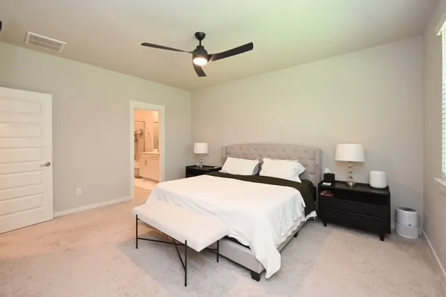 a bedroom with a bed and a ceiling fan