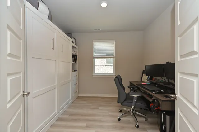a view of a workspace with furniture and a window