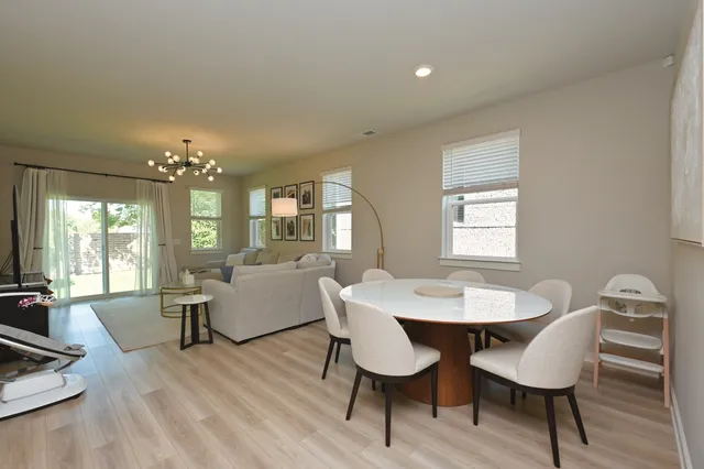 a dining room with furniture a chandelier and wooden floor