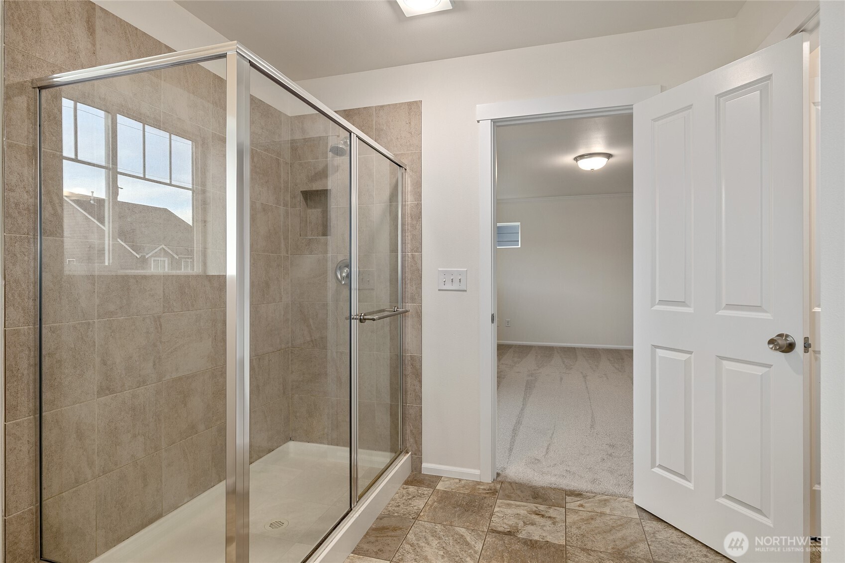 8117 175th St Court East Puyallup, WA 98375 - Photo 33 of 40 a bathroom with a shower and a glass door
