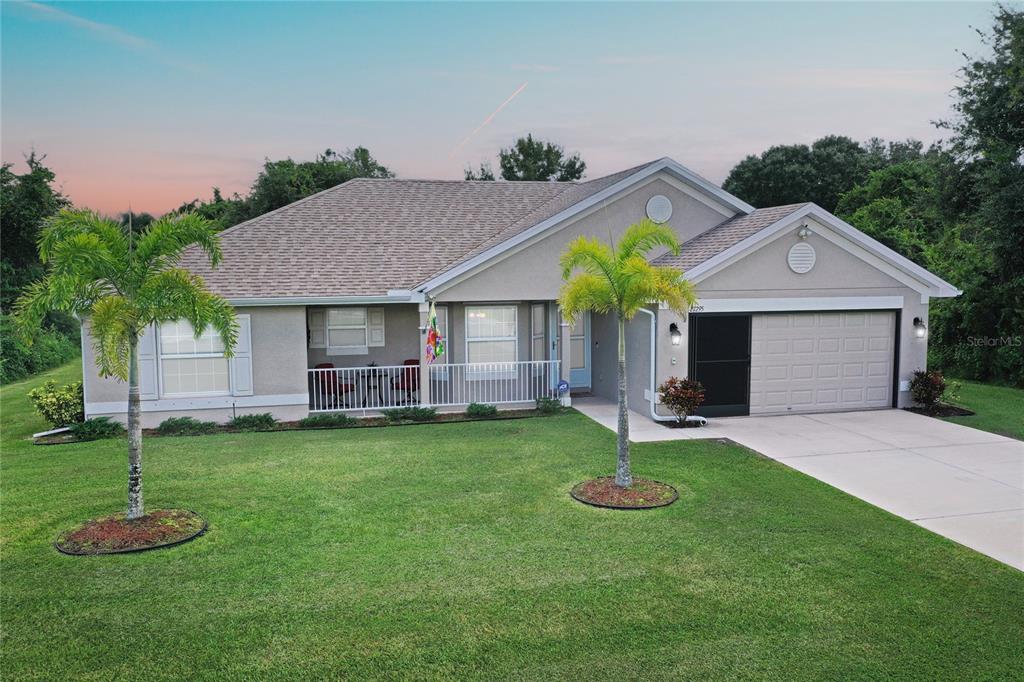 a front view of a house with a garden and yard