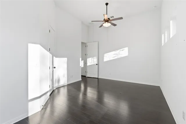 an empty room with wooden floor and white walls