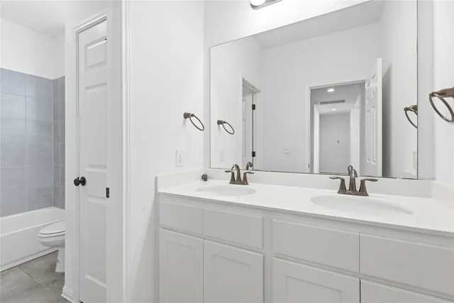 a bathroom with a double vanity sink and a mirror