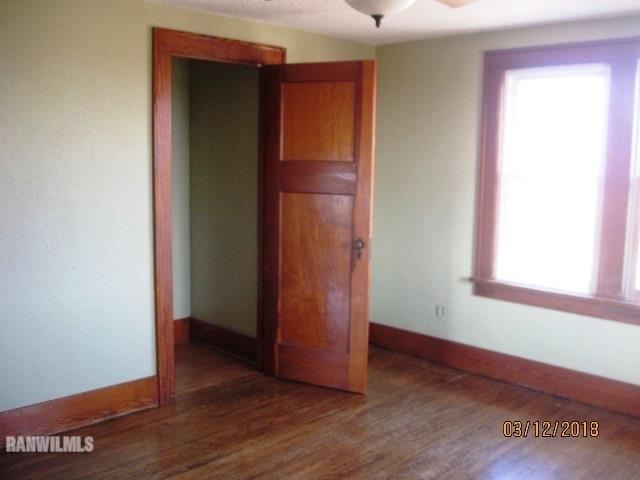16747 West White Oak Road Forreston, IL 61030 - Photo 10 of 24 an empty room with wooden floor and a window