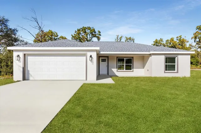 a front view of a house with a yard and a garage