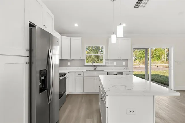 a kitchen with a sink window and refrigerator