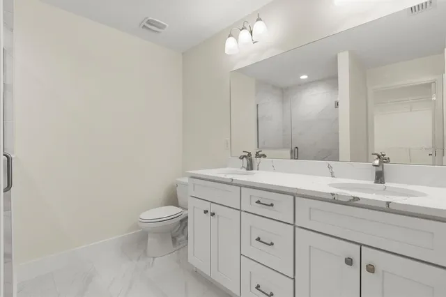 a bathroom with a toilet a sink and mirror