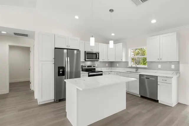 a kitchen with white cabinets and stainless steel appliances