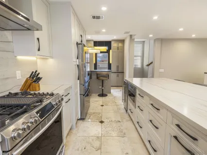 a kitchen with white cabinets stainless steel appliances and sink