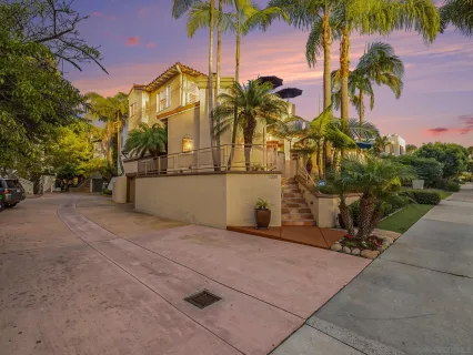 a view of a house with a yard and palm trees