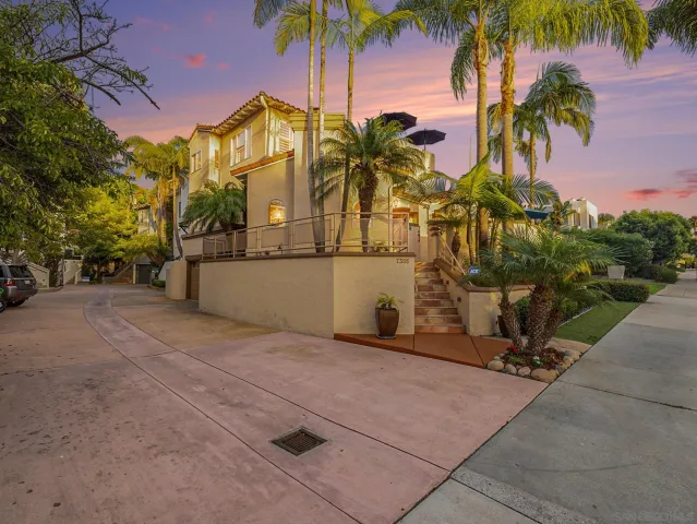 a view of a house with a yard and palm trees