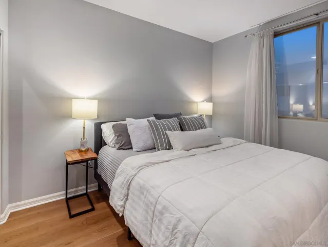 a bathroom with a granite countertop sink a toilet a mirror and shower