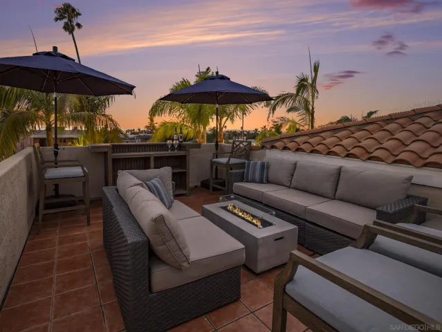 a view of a terrace with furniture and umbrella