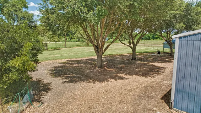a view of a wooden house with a small yard and wooden fence