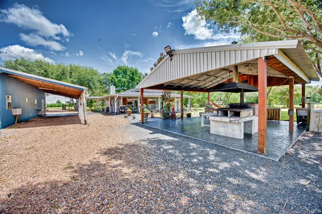 a view of patio with table and chairs under an umbrella