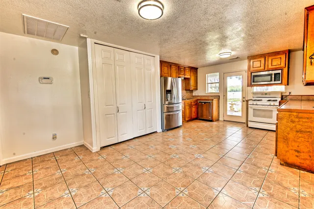 a kitchen with stainless steel appliances granite countertop a refrigerator and stove