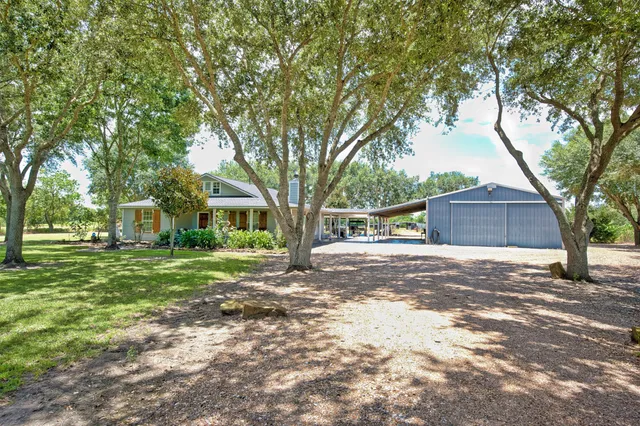 a front view of a house with a yard and trees