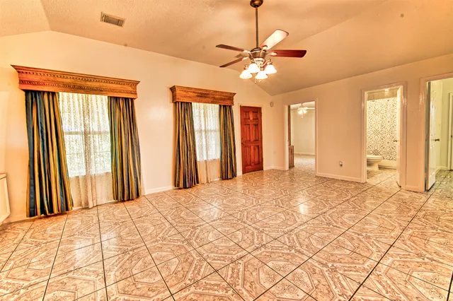 a view of a room with a ceiling fan and a window