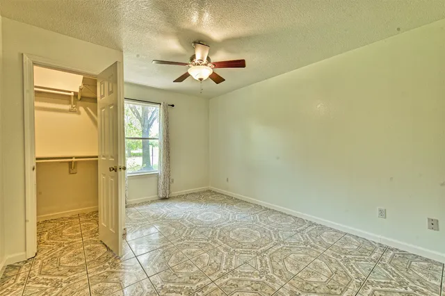 a spacious bedroom with a bed and a chandelier