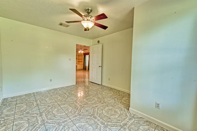 a spacious bedroom with a bed and a chandelier