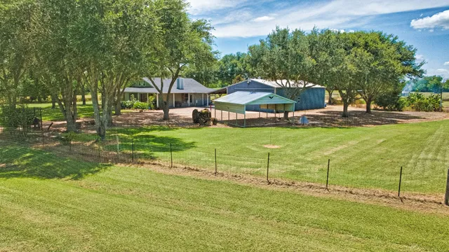 a view of a house with pool and chairs