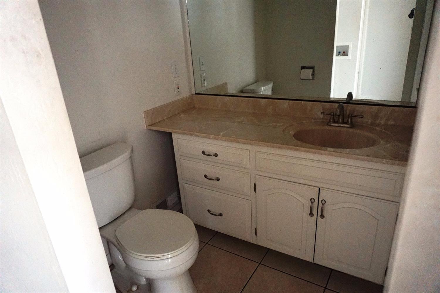1312 Talent Avenue Talent, OR 97540 - Photo 19 of 21 a bathroom with a granite countertop toilet sink and mirror