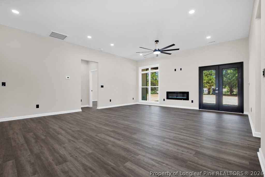 3025 Old Stage Road South Erwin, NC 28339 - Photo 8 of 50 an empty room with wooden floor a ceiling fan and windows