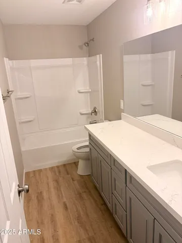 a bathroom with a granite countertop sink a toilet and bathtub