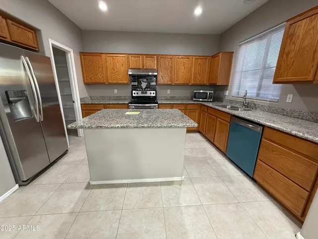 a kitchen with stainless steel appliances granite countertop a sink a stove a microwave a counter top and cabinets